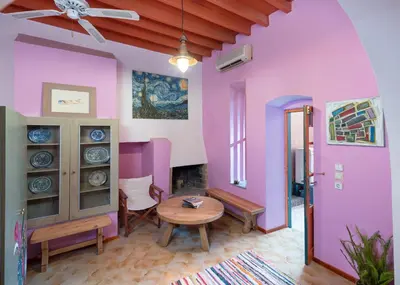a living room with pink walls and a table at Labyrinthos Arts Guest House in Rhodes Town
