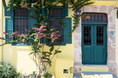 a building with a blue door and flowers at Labyrinthos Arts Guest House in Rhodes Town