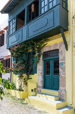 a building with a green door and a balcony at Labyrinthos Arts Guest House in Rhodes Town