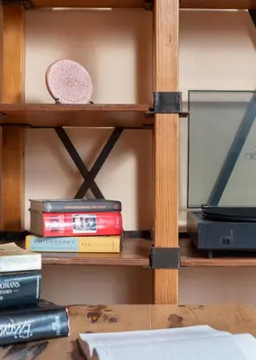 a stack of books on a shelf with a tv at Labyrinthos Arts Guest House in Rhodes Town