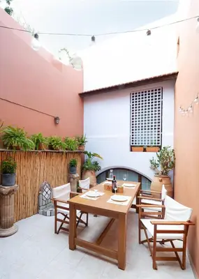 a patio with a table and chairs and a fireplace at Labyrinthos Arts Guest House in Rhodes Town
