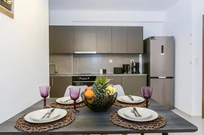 a kitchen with a table with plates and wine glasses at Katerina & Stefanos Family apartments in Archangelos