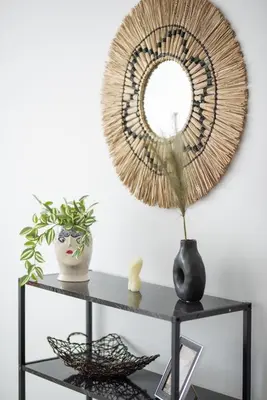 a mirror on a shelf with a table with a plant at Katerina & Stefanos Family apartments in Archangelos