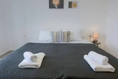 a bedroom with a bed with towels on it at Katerina & Stefanos Family apartments in Archangelos