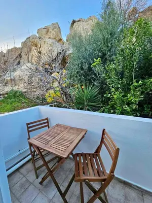 a wooden table and two chairs on a patio at Lindos Tsambika Studios in Líndos