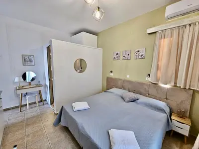 a bedroom with a blue bed and a table at Lindos Tsambika Studios in Líndos