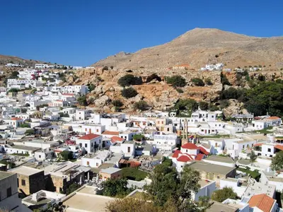 a view of a town with a mountain in the background at Lindos Tsambika Studios in Líndos