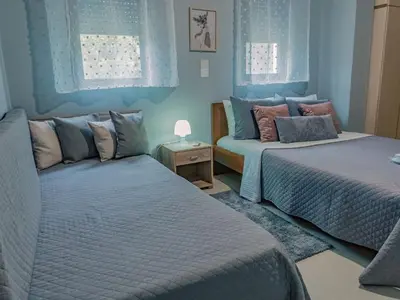 two beds in a bedroom with blue walls at Papa’s house in Kalithies