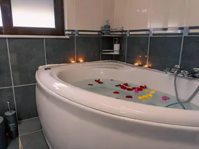 a bathroom with a bath tub with candles in it at Papa’s house in Kalithies