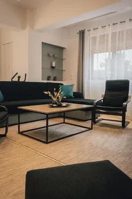 a living room with a coffee table and chairs at Papa’s house in Kalithies