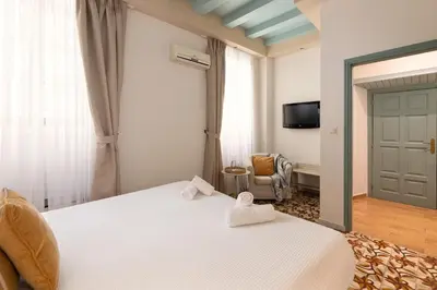 a bedroom with a bed and a tv and a door at Casa Antica in Rhodes Town