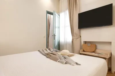a bedroom with a bed with a television on the wall at Casa Antica in Rhodes Town