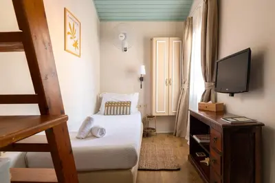 a small bedroom with a bed and a television at Casa Antica in Rhodes Town
