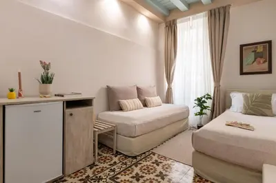 a bedroom with a bed and a couch and a window at Casa Antica in Rhodes Town