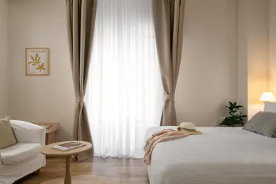 a bedroom with a bed and a couch and a window at Casa Antica in Rhodes Town