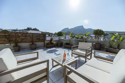 a patio with chairs and a table on a roof at Archangelos SKY Garden Apartment in Archangelos