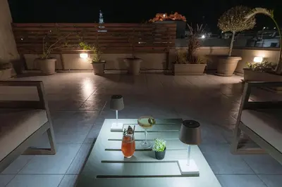 a table with two vases on a patio at night at Archangelos SKY Garden Apartment in Archangelos