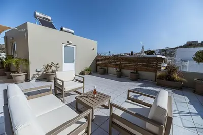 a patio with chairs and a table on a roof at Archangelos SKY Garden Apartment in Archangelos