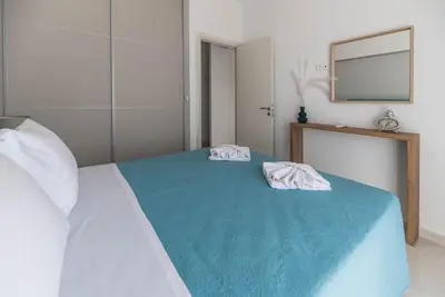 a bedroom with a bed with two towels on it at Archangelos SKY Garden Apartment in Archangelos