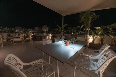 a table and chairs on a patio at night at Archangelos SKY Garden Apartment in Archangelos