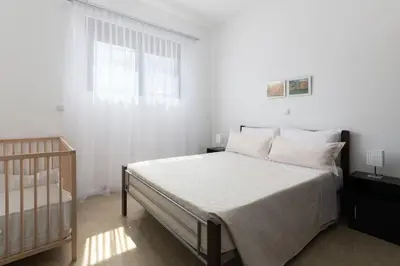a white bedroom with a bed and a window at Luxurious and modern house near town and beach in Asgourou