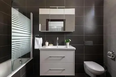 a bathroom with a sink and a toilet and a mirror at Luxurious and modern house near town and beach in Asgourou