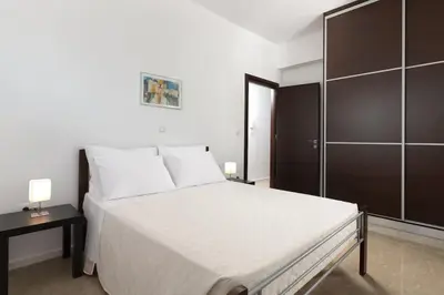 a bedroom with a large white bed and a cabinet at Luxurious and modern house near town and beach in Asgourou