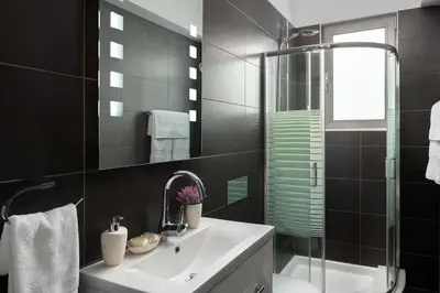 a bathroom with a sink and a shower at Luxurious and modern house near town and beach in Asgourou