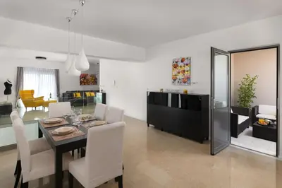 a dining room and living room with a table and chairs at Luxurious and modern house near town and beach in Asgourou