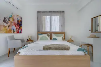 a bedroom with a large bed with a wooden headboard at Gia's Luxury Residence in Asgourou