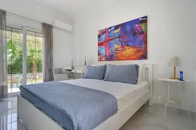 a bedroom with a bed and a painting on the wall at Gia's Luxury Residence in Asgourou