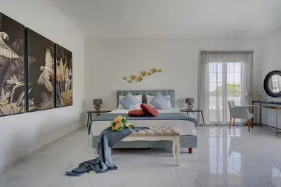 a bedroom with a bed and a table with flowers on it at Gia's Luxury Residence in Asgourou