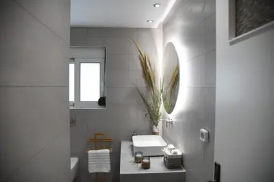 a bathroom with a sink and a toilet and a mirror at City Center Luxury Spacious apt A&M in Rhodes Town