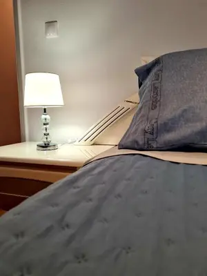 a bedroom with a bed with a lamp on a desk at City Center Luxury Spacious apt A&M in Rhodes Town