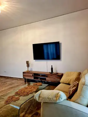 a living room with two couches and a flat screen tv at City Center Luxury Spacious apt A&M in Rhodes Town