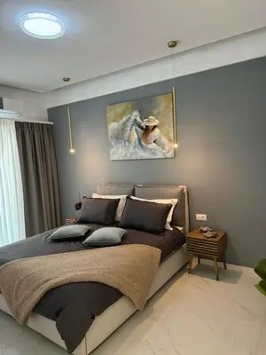 a bedroom with a bed with a painting on the wall at Cozy City Center Apartment in Rhodes Town