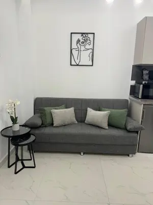 a living room with a gray couch and a table at Cozy City Center Apartment in Rhodes Town