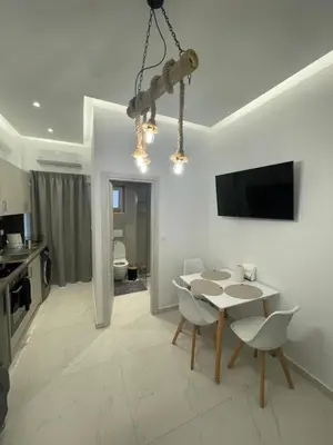a white dining room with a table and chairs at Cozy City Center Apartment in Rhodes Town
