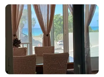 a room with a table and chairs and a large window at Sea view Holiday House Ialisos in Triánta