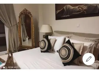 a bedroom with a bed with pillows and a mirror at Sea view Holiday House Ialisos in Triánta