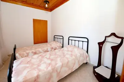 two beds in a room with white walls at Villa Magdalini in Halki