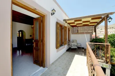 a porch of a house with a wooden door at Villa Magdalini in Halki