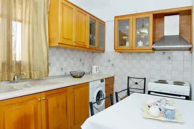a kitchen with wooden cabinets and a sink and a stove at Villa Magdalini in Halki