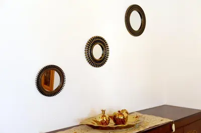 a table with two mirrors on a white wall at Villa Magdalini in Halki