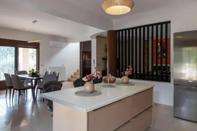 a kitchen and dining room with a table and chairs at Physis Luxury Villa in Archangelos