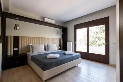 a bedroom with a bed and a large window at Physis Luxury Villa in Archangelos