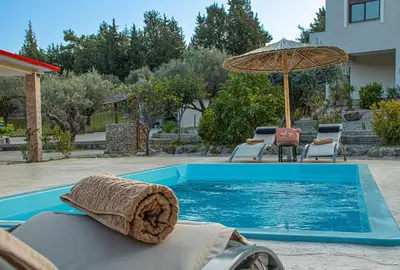 a swimming pool with a towel and an umbrella at Physis Luxury Villa in Archangelos