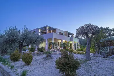 a large house with trees in front of it at Physis Luxury Villa in Archangelos