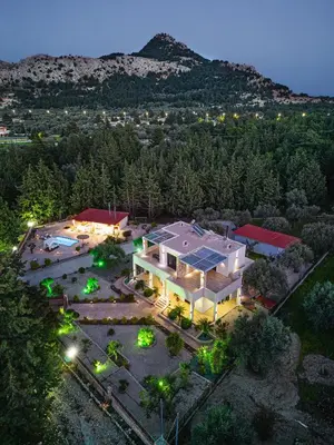 an aerial view of a large house with lights at Physis Luxury Villa in Archangelos
