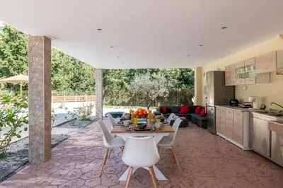 a kitchen and living room with a table and chairs at Physis Luxury Villa in Archangelos